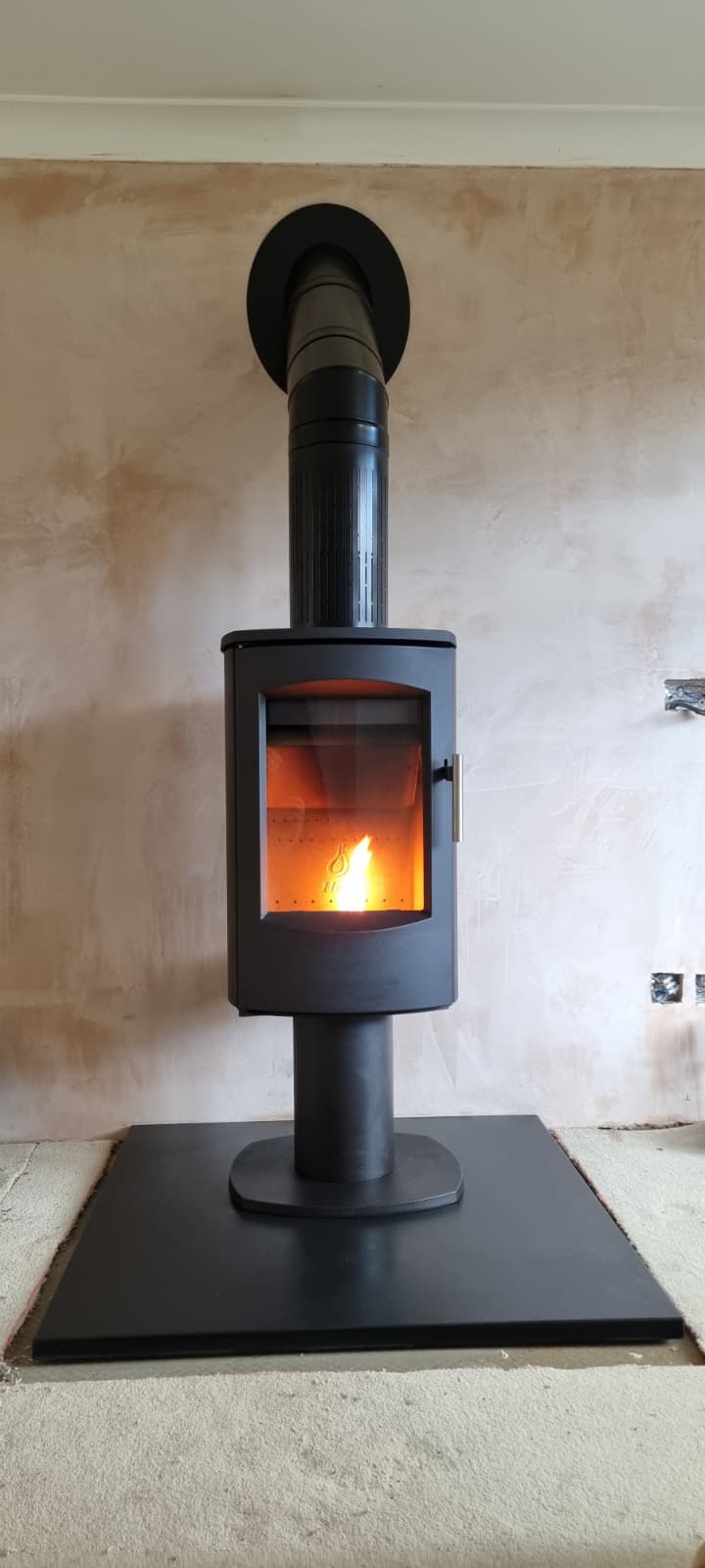 Contemporary freestanding stove against a plastered feature wall