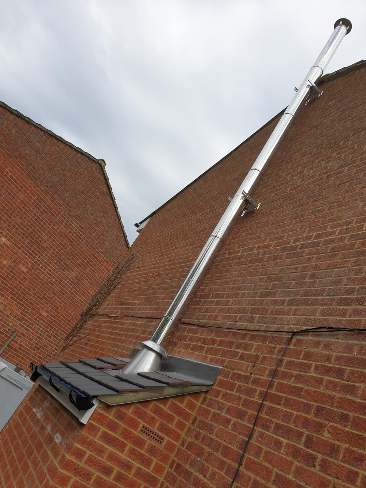 Twin-wall flue system installed to HETAS standards on a brick wall in Windsor