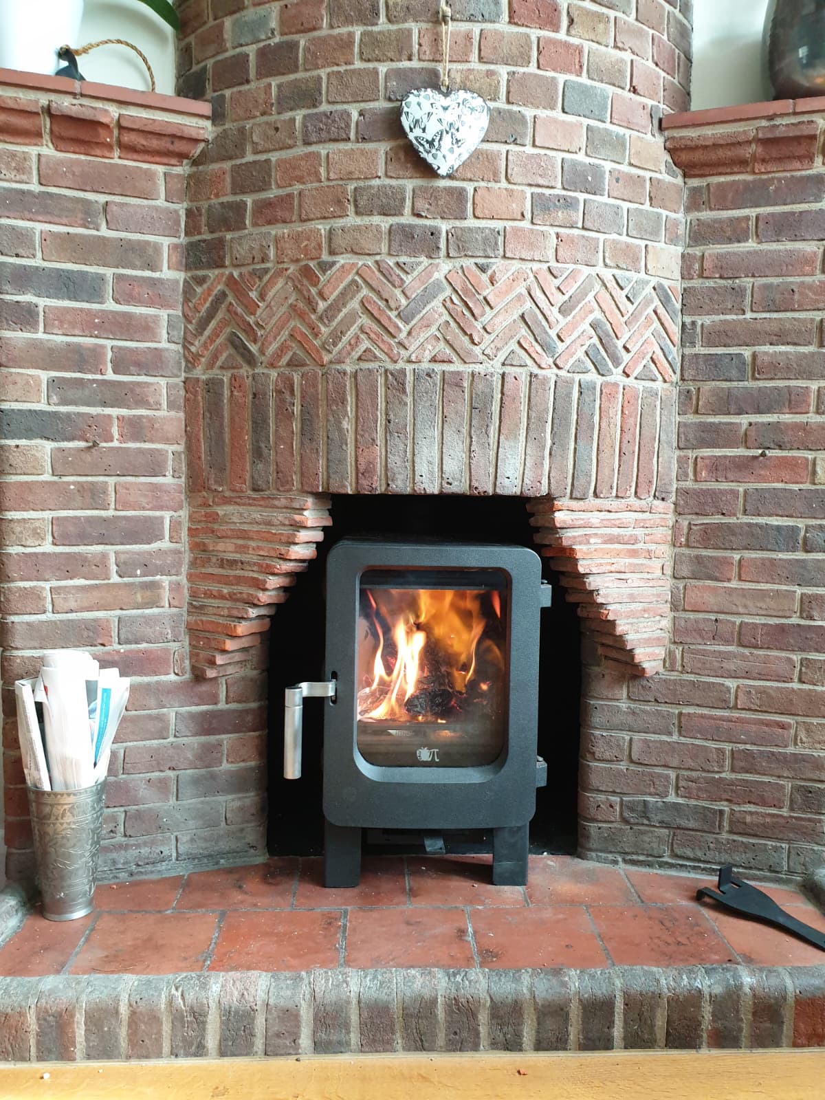 Bespoke brick fireplace with decorative arch and freestanding stove