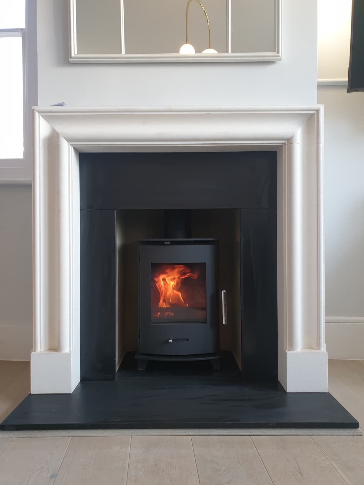 Inset cassette stove framed by a tall painted mantel