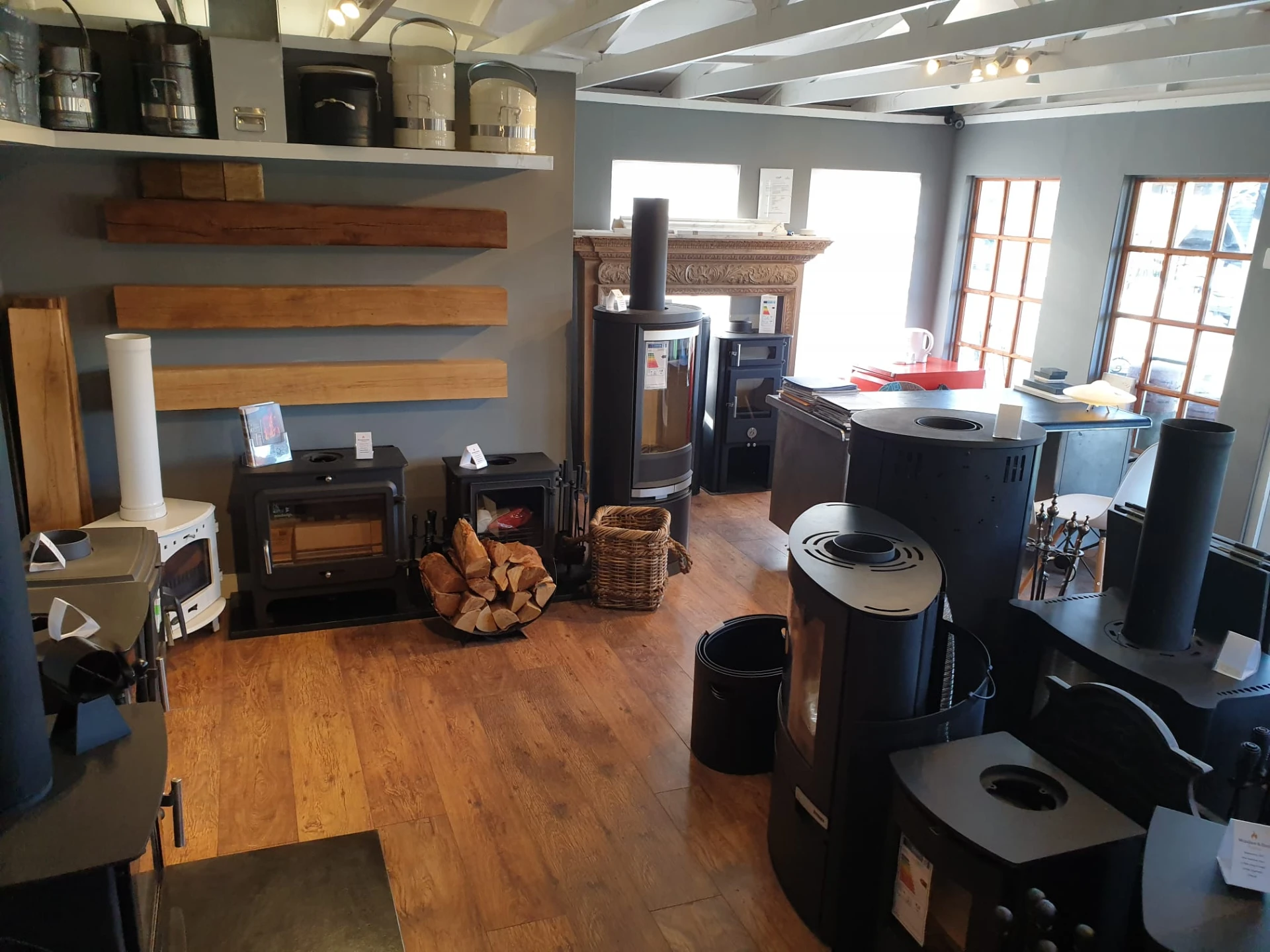 Oak beam mantel samples and cast iron stoves on display in the Windsor & Eton Stoves showroom