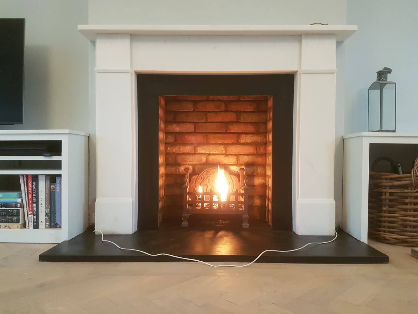 Restored brick-lined fireplace fitted with a period fire basket