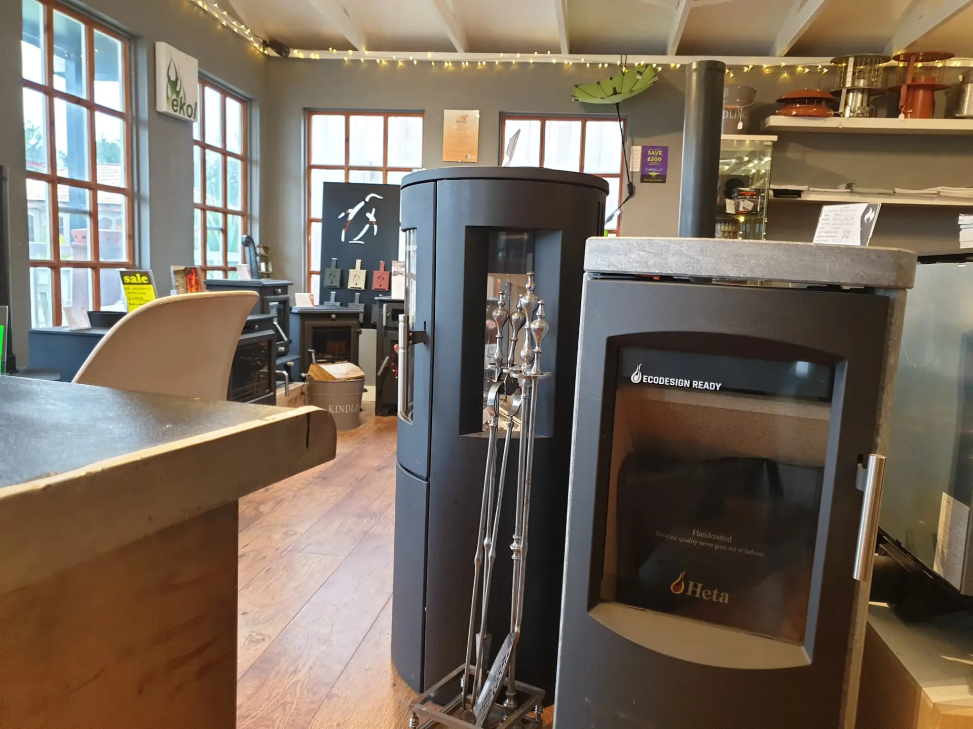 Ecodesign Ready Heta stove and contemporary cylindrical stove on the showroom floor
