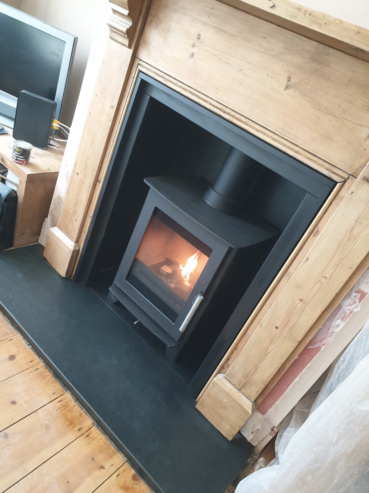 Inset stove installation in a dark surround with slate hearth